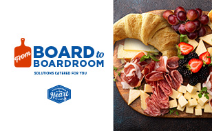 From board to boardroom text in blue and white. Cutting board icon in orange. Image of charcuterie on wooden board. Assortment includes salted meats, croissants, biscuits, cheese, grapes, and berries.