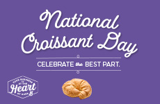 A senior citizen woman wearing yellow breaking apart a croissant for National Croissant Day